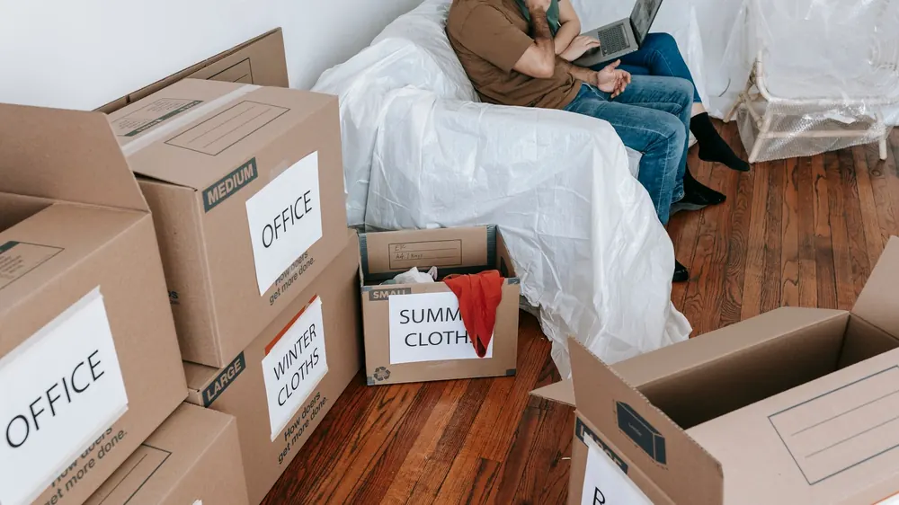 Labelled moving boxes stacked in an apartment hallway, ready for a permitted move